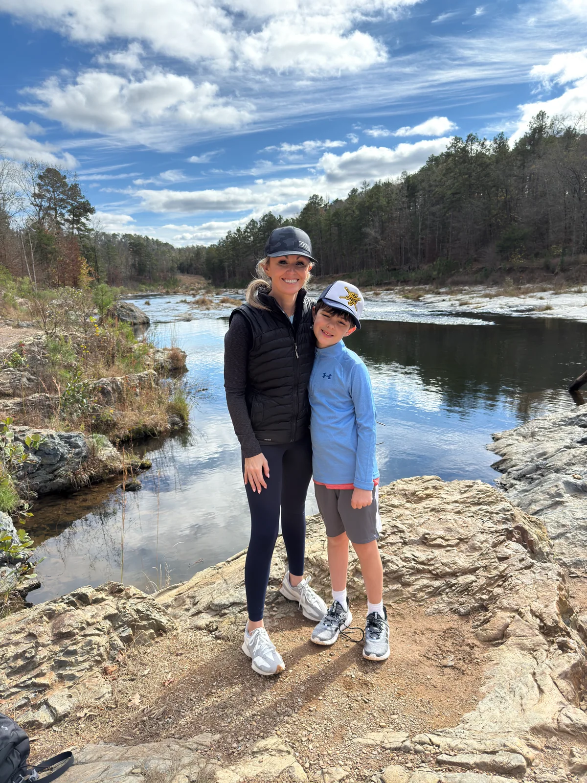 Dr. Natalie Smith outdoors by a river with her son
